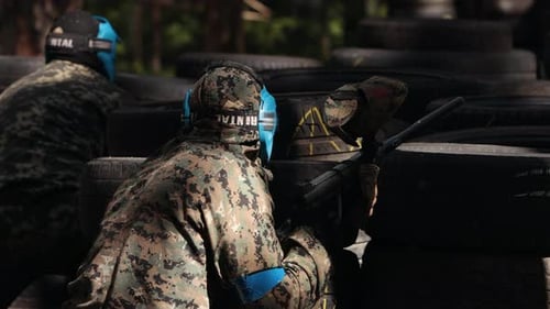 Portrait d'adultes joyeux jouant au paintball sur le champ de bataille