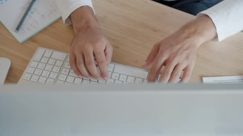 High Angle View Closeup of Male Hands Working with Pc Keyboard Typing Indoors at Desk