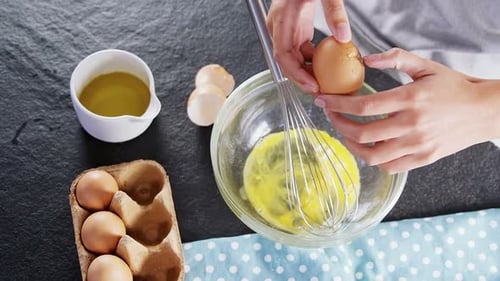 Cracking Egg into Glass Bowl with Whisk