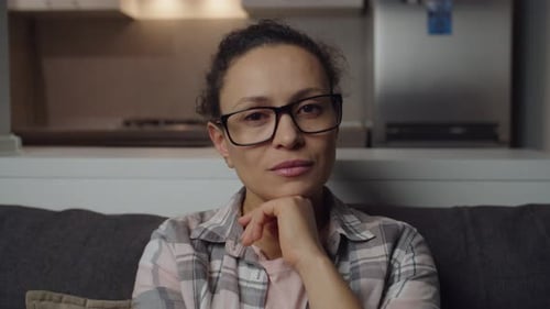 Woman with Glasses Sitting on a Couch
