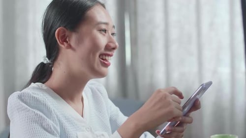 Woman Using Smartphone in Bright Home Office