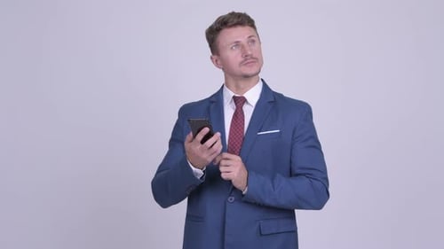 Young Adult Man Using Phone in Blue Suit