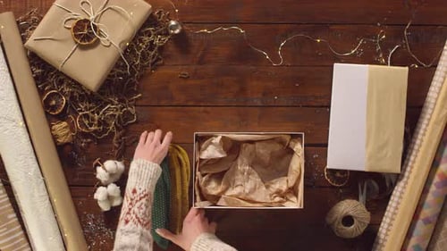 Woman Packing Christmas Gifts into a Box
