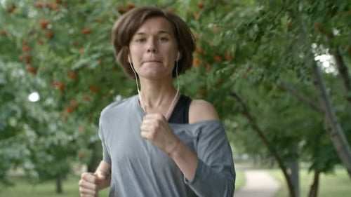 Young Woman Listening to Music During Run
