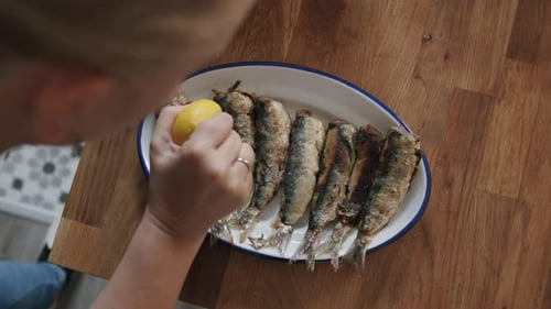 Woman Prepares Fresh Sardines with Lemon