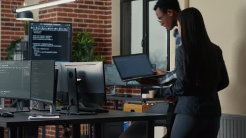 Diverse Team Collaborating on Computer Code in Modern Office