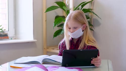Girl With Mask Uses Tablet While Studying