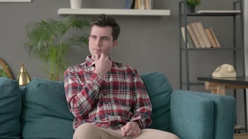 Man Sitting on Sofa Thinking