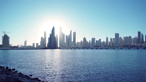 Dubai Downtown skyline with waves on sea beach, United Arab Emirates or UAE
