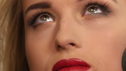 Maskenbildnerin, die Schimmerpuder auf das Gesicht der Frau Nahaufnahme