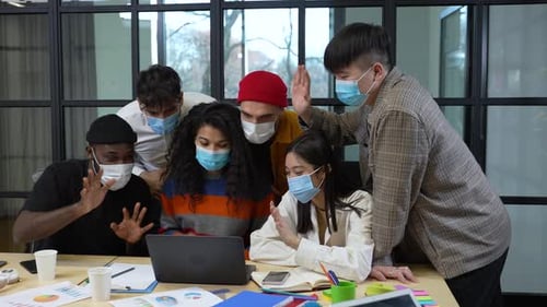 Diverse Team Collaborating on Laptop Wearing Face Masks