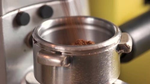 Ground Coffee Fills a Silver Portafilter Close Up