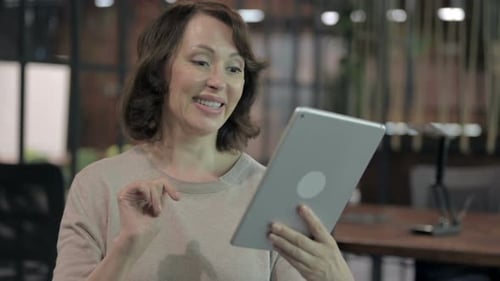 Woman Video Calling on Tablet in Modern Office
