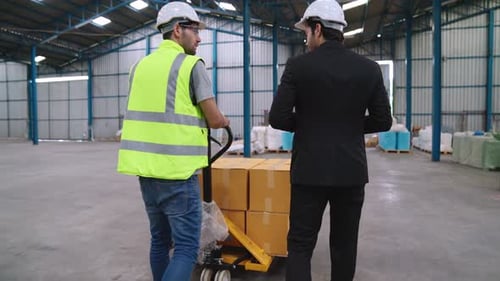 Factory Workers Deliver Boxes Package on a Pushing Trolley in the Warehouse