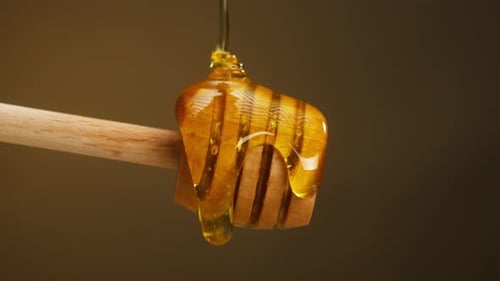 Golden Honey Dripping From Wooden Honey Dipper
