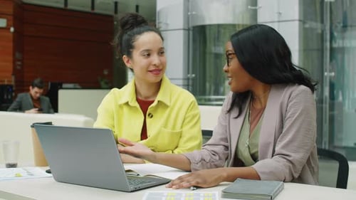 Diverse Businesswomen Using Laptop and Speaking at Work