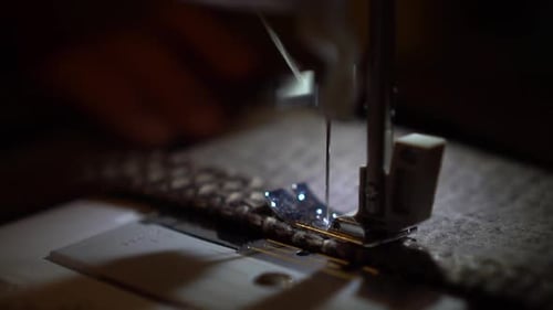 On a Sewing Machine Sew Clothes Close-up. Dressmaker Sews Fabric. Slow Motion.