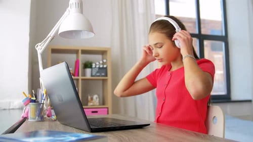 Girl Studying and Typing on Laptop at Desk