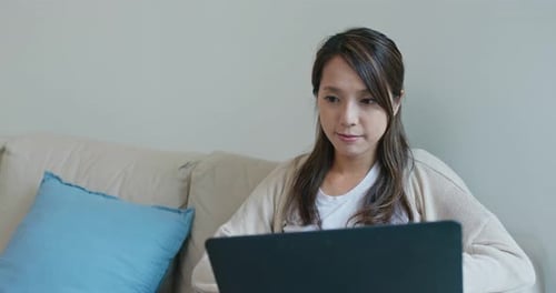 Woman Works on Laptop at Home on Couch
