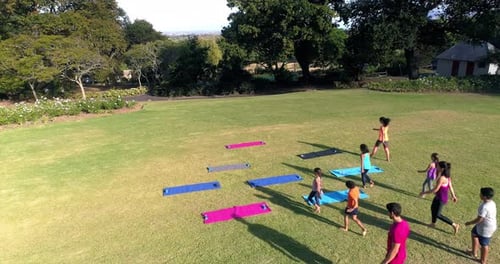 Group of people performing yoga in the park 4k