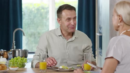 Couple Eating Breakfast Together at Kitchen Table