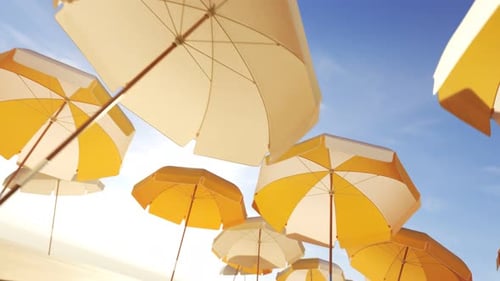 Vacations and travel concept. Yellow umbrellas or parasols against blue sky.