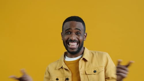 Enthusiastic Young Adult Gesturing and Smiling at Camera