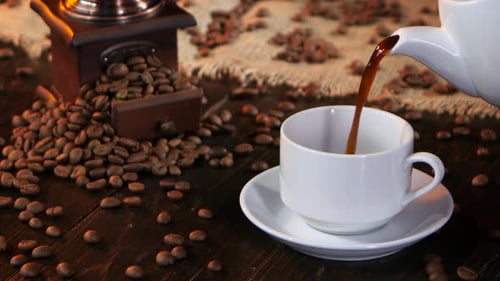Coffee Being Poured Into a Cup With Beans