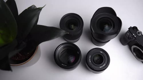 Camera Lenses and Camera Body on White Surface
