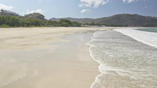 Beautiful Cloudy Sky with the Drone Hovering Above the Wet Sandy Shore in Indonesia