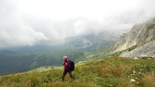Young Woman with Backpack Walks Towards the Summit. Slow Motion. Lady Is Hiking in Beautiful