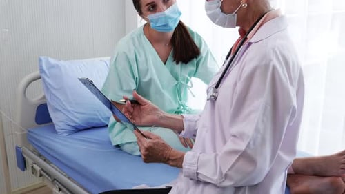 Doctor Reviews Clipboard with Young Woman Patient