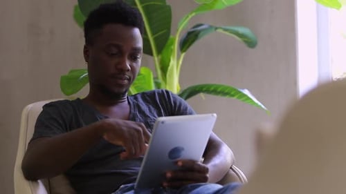 Young Adult Using Tablet in Modern Home