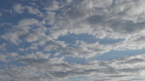 Wolken bewegen sich gegen den blauen Himmel