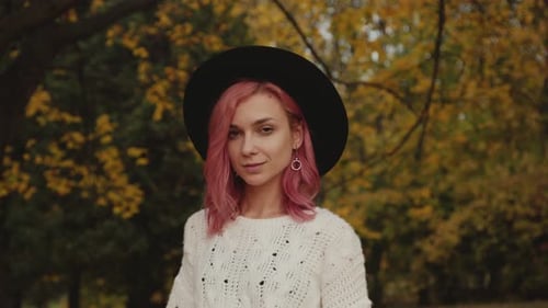 Passionate Girl Blinks Eye To Camera, Poses and Turns in Autumn Park