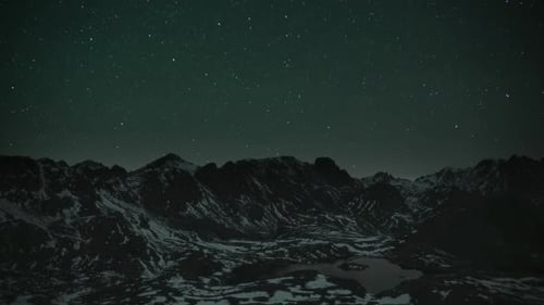 Dramatic Stars Above Dark Snowy Mountain Range