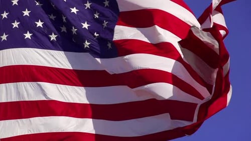 American Flag Waving Proudly Against Blue Sky