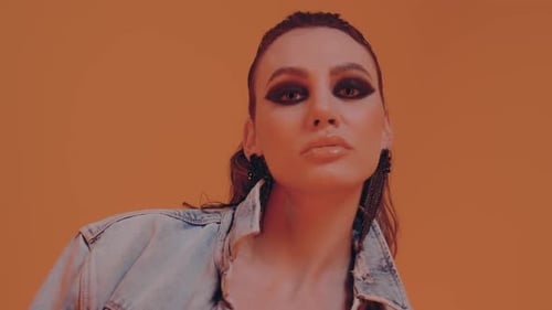 Woman in Denim Jacket Poses with Bold Makeup