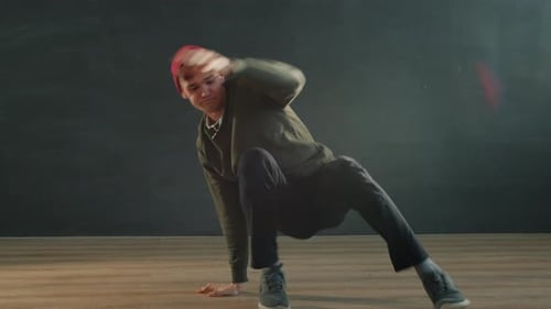 Young Man Hipster Performing Breakdance Show in Dark Room Enjoying Dance