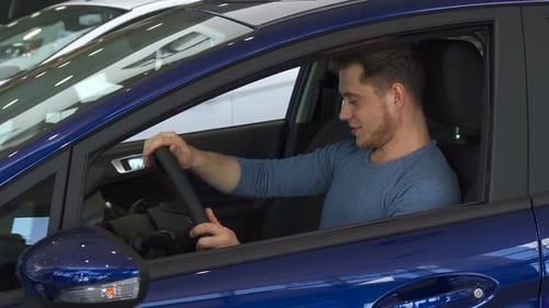 Young Man Sitting in New Car Smiling