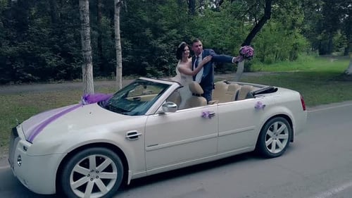 Hübscher Verlobter küsst Braut im festlichen Cabrio