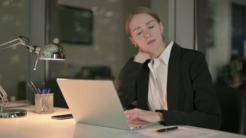 Woman Working Late at Desk Experiencing Neck Pain