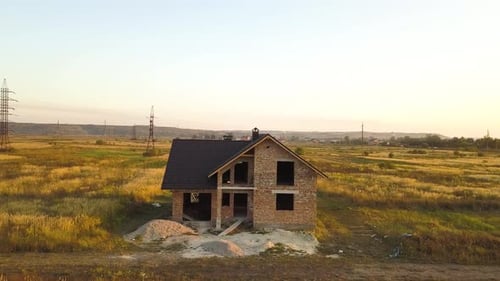 Aerial view of unfinished house with wooden roof structure covered with metal tile sheets under