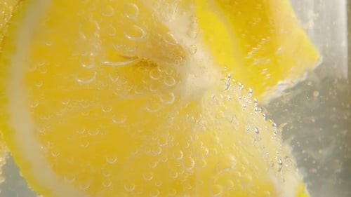 Lemon Slices Floating in Bubbly Water, Close-Up