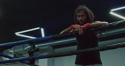 Boxer Rests in Boxing Ring During Training