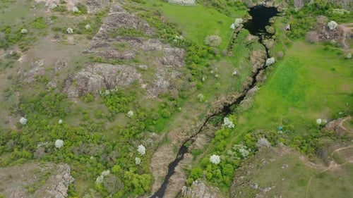 A Topdown Aerial View of a Stream Flowing Through a Canyon in the Mountains