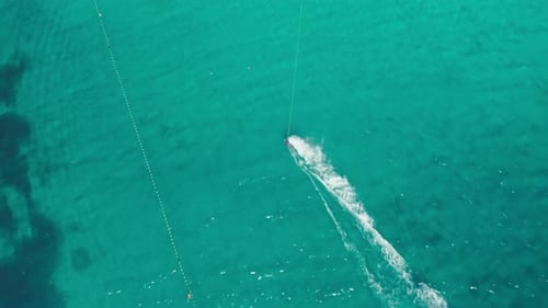 Mutige Person fährt mit dem Kabel-Wakeboarden entlang des azurblauen Meeres