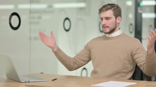 Man Talking at Computer in Office Setting