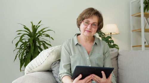 Senior Woman Relaxing at Home Using Tablet