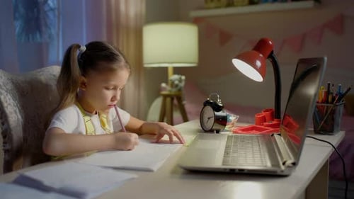 Girl Focused on Homework in Bedroom at Night